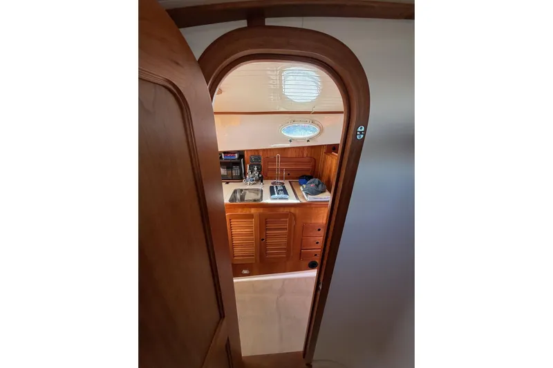 Timothy E Yacht Photos Pics Interior view of 2001 Hinckley Classic Picnic Boat, featuring wooden cabinetry and compact kitchen area.