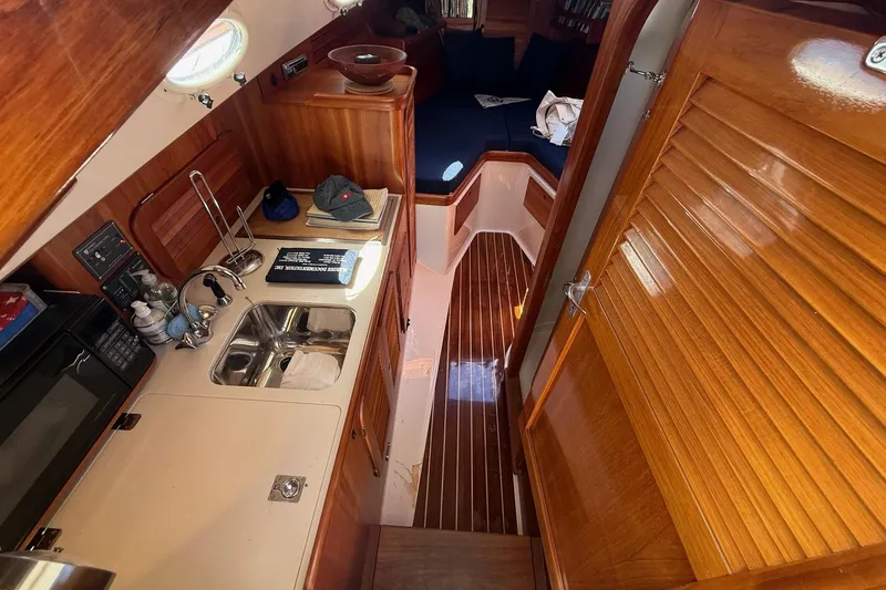 Timothy E Yacht Photos Pics 2001 Hinckley Classic Picnic Boat interior with wooden cabinetry and compact kitchen area.