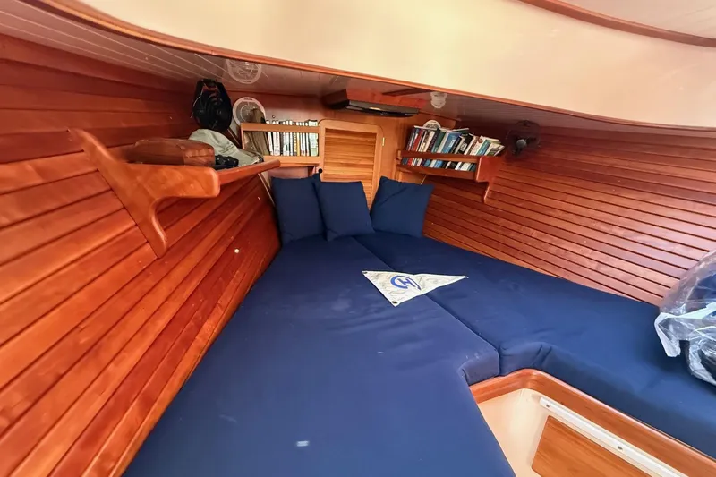 Timothy E Yacht Photos Pics Cozy cabin interior of 2001 Hinckley Classic Picnic Boat with wooden paneling and blue cushions.