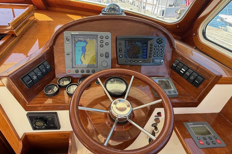 Timothy E Yacht Photos Pics Helm of 2001 Hinckley Classic Picnic Boat with navigation instruments and wooden steering wheel.