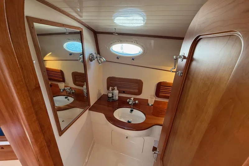 Timothy E Yacht Photos Pics Elegant wooden interior of 2001 Hinckley Classic Picnic Boat bathroom with sink and mirror.