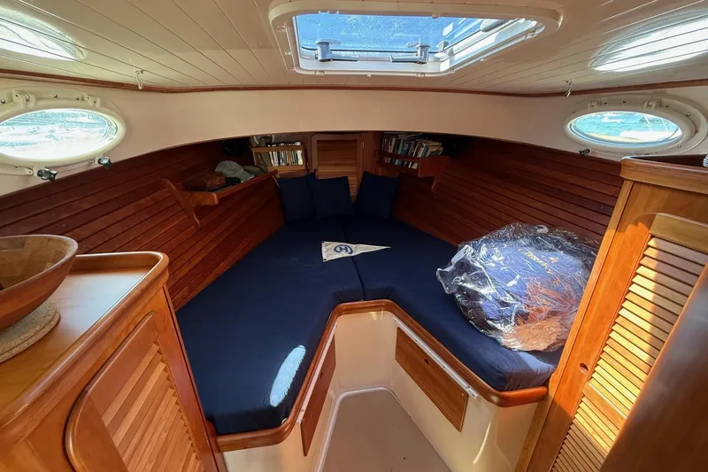 Timothy E Yacht Photos Pics Interior of 2001 Hinckley Classic Picnic Boat with cozy wooden cabin and blue cushions.