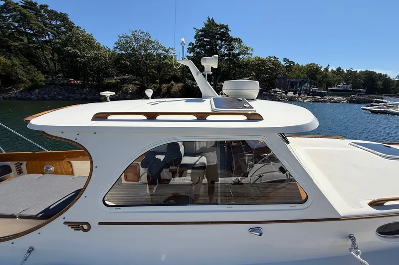 Timothy E Yacht Photos Pics 2001 Hinckley Classic Picnic Boat on serene water with lush trees in the background.