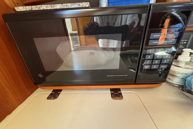 Timothy E Yacht Photos Pics Microwave inside 2001 Hinckley Classic Picnic Boat galley, featuring control panel and wooden accents.