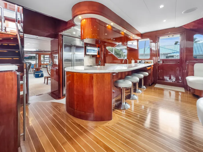 Jusmad Yacht Photos Pics Luxurious interior of 2005 Ocean Alexander 80 yacht with polished wood and modern bar seating.