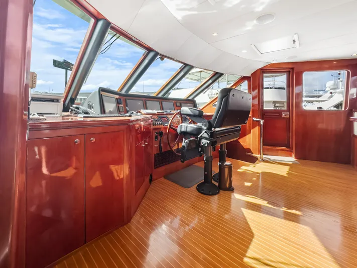 Jusmad Yacht Photos Pics Pilothouse of 2005 Ocean Alexander 80 yacht with polished wood interior and captain's chair.