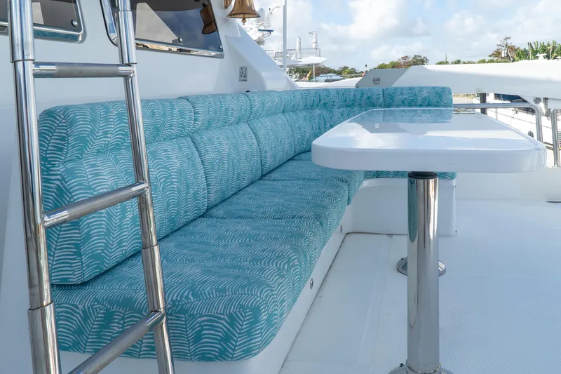 Jusmad Yacht Photos Pics Outdoor seating area on 2005 Ocean Alexander 80 yacht with blue cushions and table.