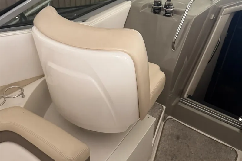  Yacht Photos Pics Captain's seat on 2013 Sea Ray 370 Sundancer boat, featuring beige upholstery and control panel.