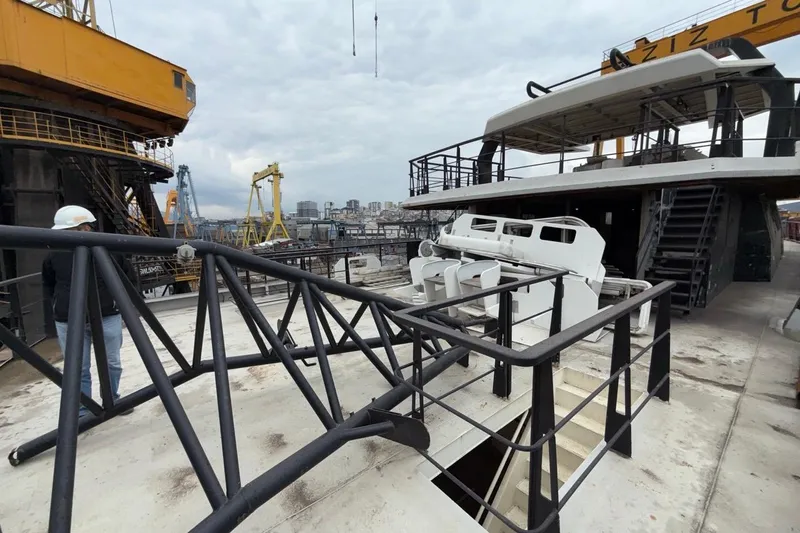 Nirvana Yacht Photos Pics A Soyaslan Custom 2027 yacht under construction at a shipyard with cranes in the background.
