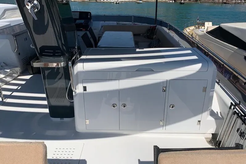  Yacht Photos Pics Flybridge of 2021 Sirena 64 yacht with seating and storage, docked by the water.