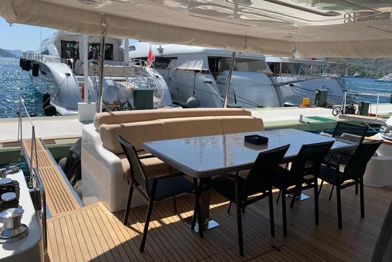  Yacht Photos Pics Outdoor dining area on a 2021 Sirena 64 yacht, docked with scenic ocean view.