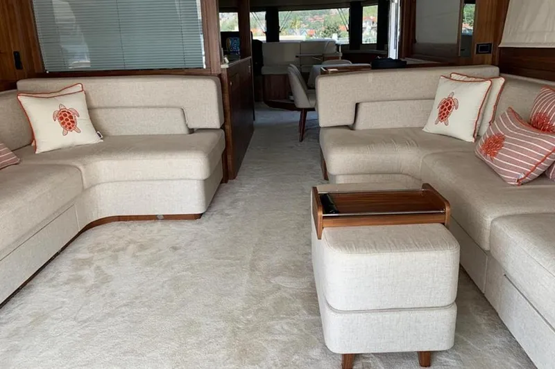  Yacht Photos Pics Luxurious interior of 2021 Sirena 64 yacht with beige seating and turtle-themed pillows.