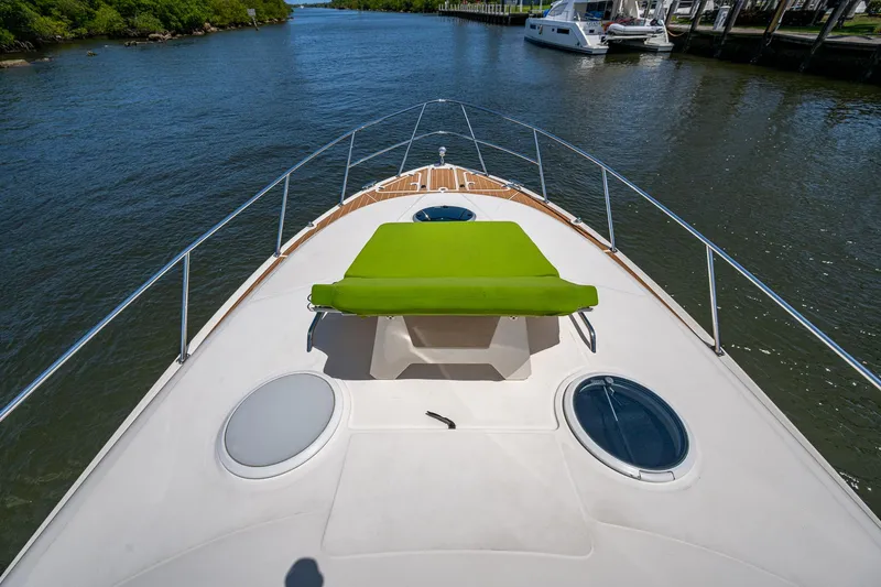  Yacht Photos Pics Bow view of 2006 Regal Commodore 3560 IO yacht with green sunpad, cruising on a river.