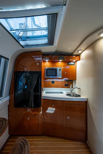  Yacht Photos Pics 2006 Regal Commodore 3560 IO yacht interior with kitchenette, featuring wood cabinetry and modern appliances.