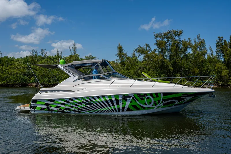  Yacht Photos Pics 2006 Regal Commodore 3560 IO boat with vibrant green and black design on a calm waterway.