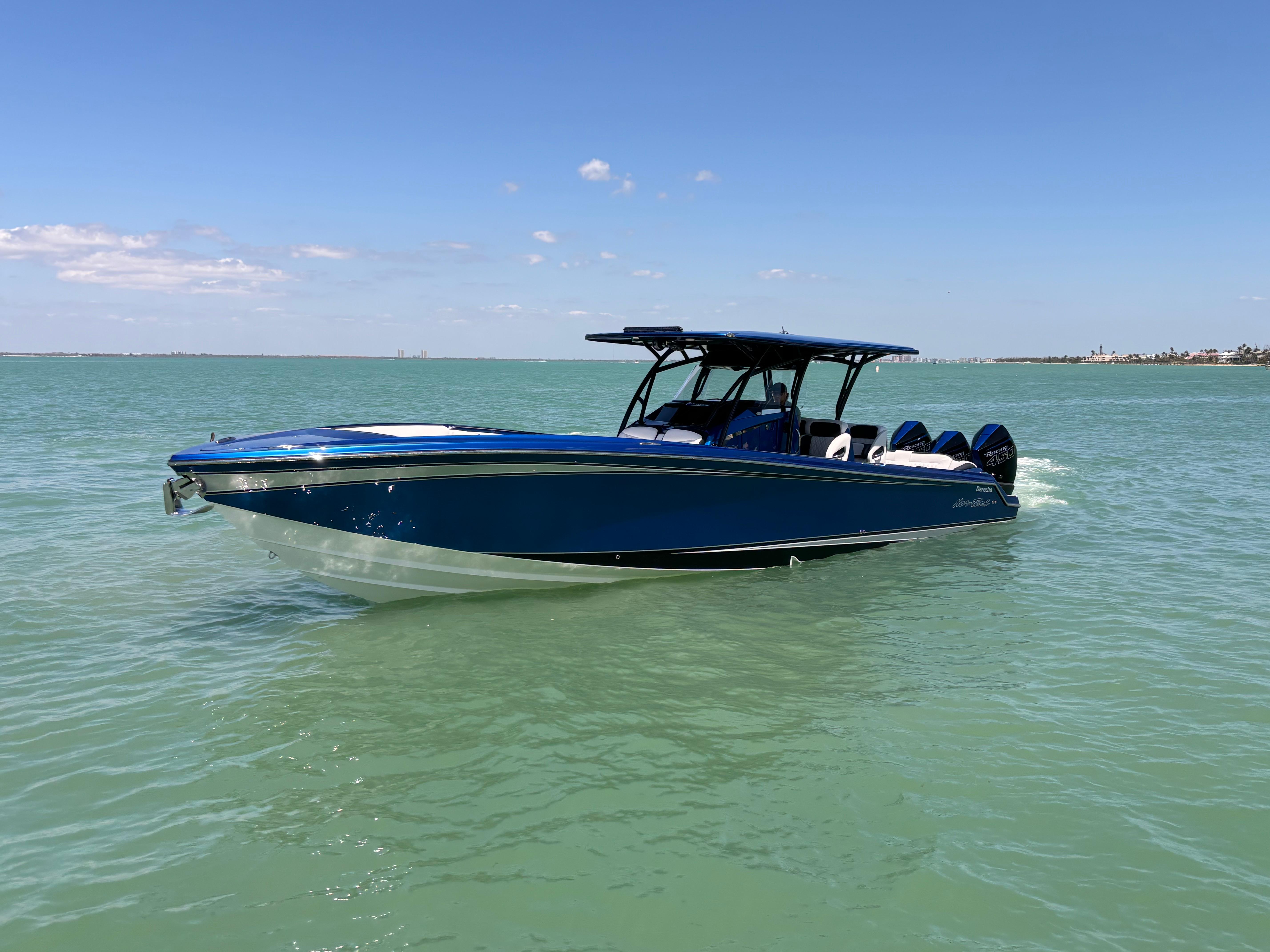 2020 Nor-Tech 390 Sport boat cruising on calm, turquoise waters under a clear blue sky.