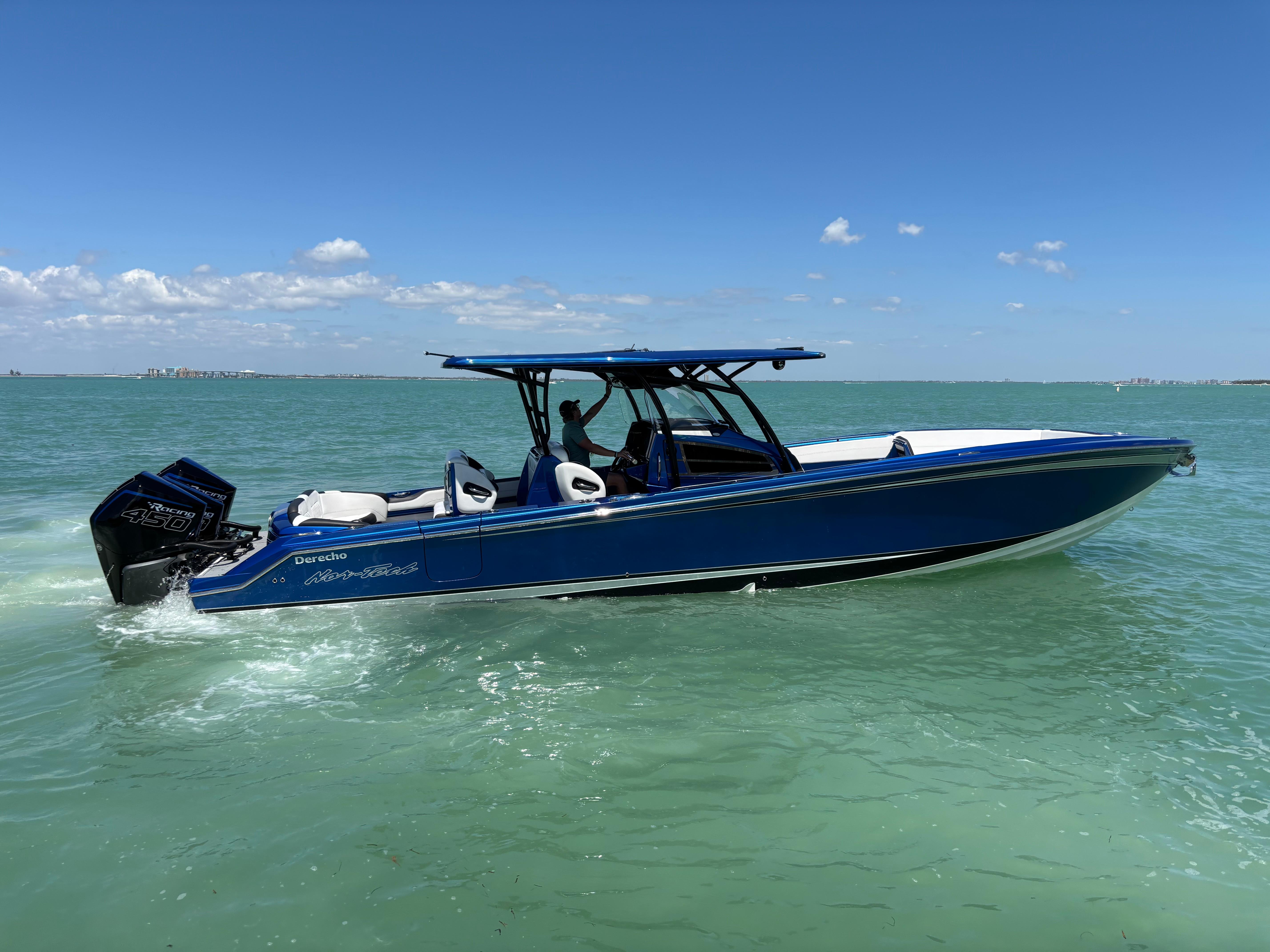 2020 Nor-Tech 390 Sport boat cruising on clear blue water under a sunny sky.