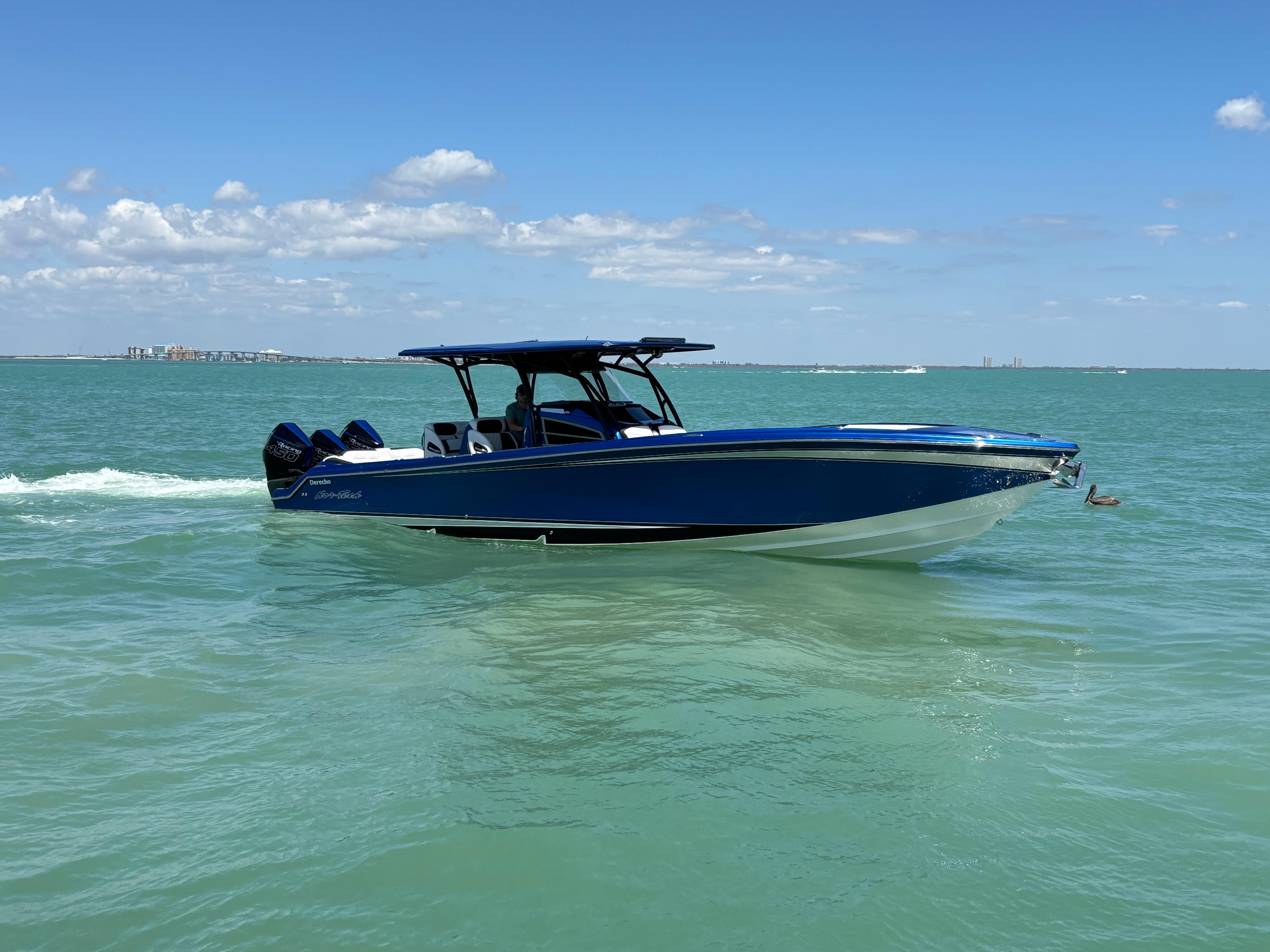 2020 Nor-Tech 390 Sport boat cruising on clear blue water under a sunny sky.