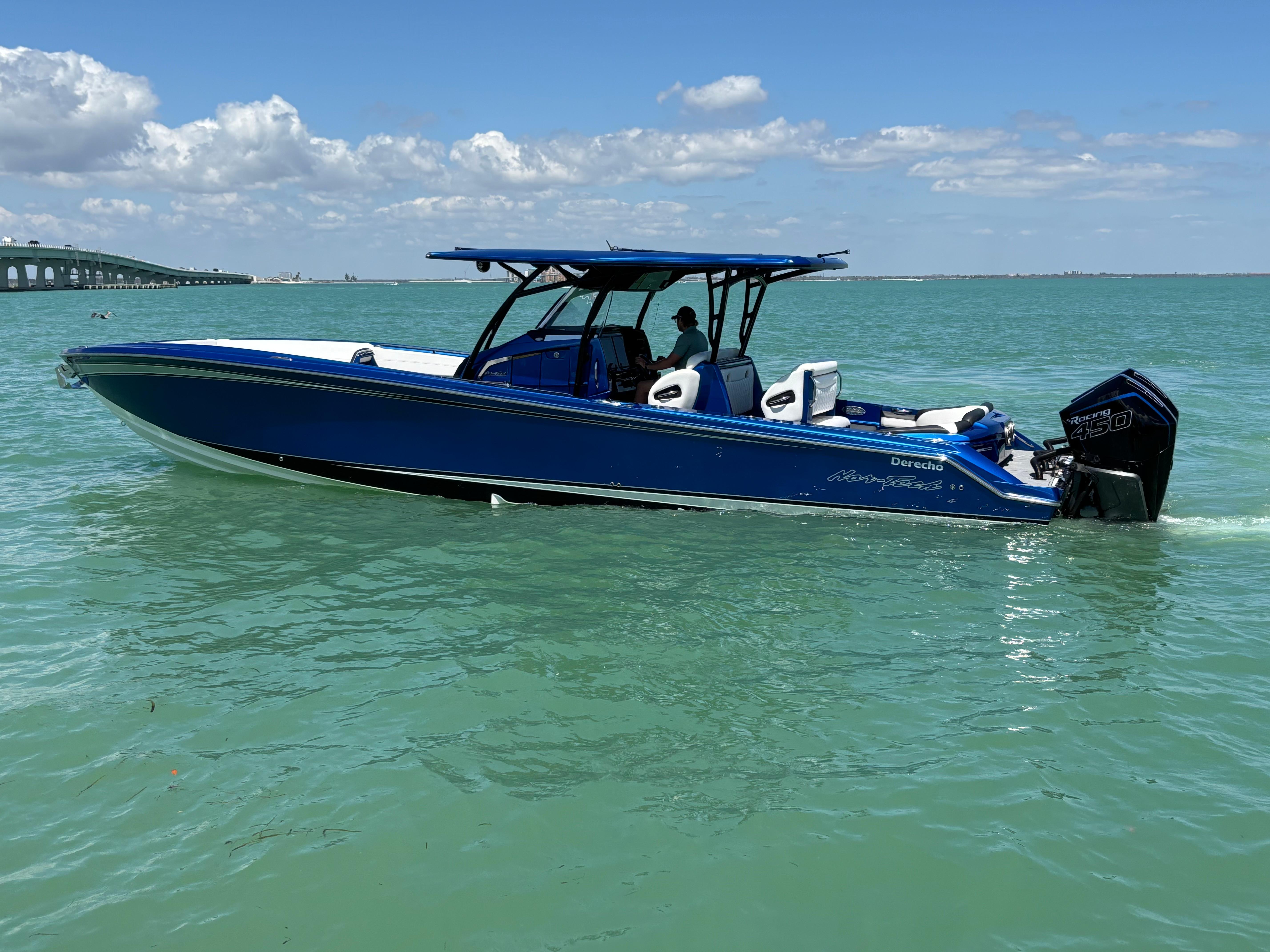2020 Nor-Tech 390 Sport boat in blue on calm sea under clear sky.
