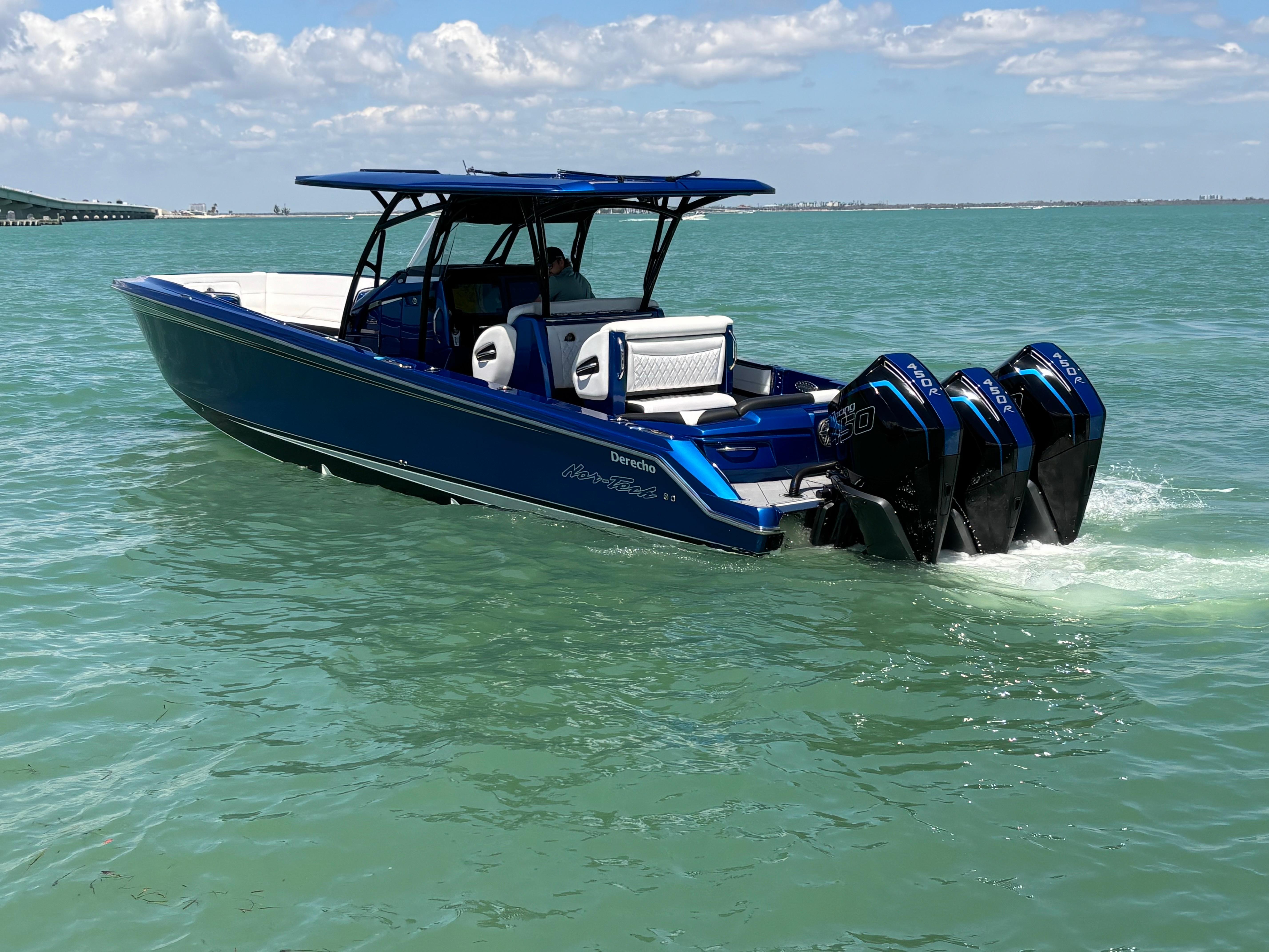 2020 Nor-Tech 390 Sport boat cruising on clear blue water under a sunny sky.