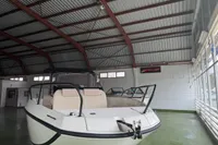 2025 Quicksilver 705 Open boat in a spacious indoor showroom.