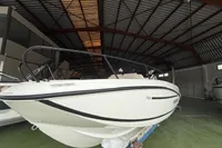2025 Quicksilver 705 Open boat in a spacious indoor storage facility.