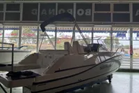 2025 Quicksilver 705 Open boat displayed indoors with canopy and sleek design.