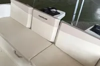 Quicksilver 705 Open 2025 boat interior with beige seating in a showroom.