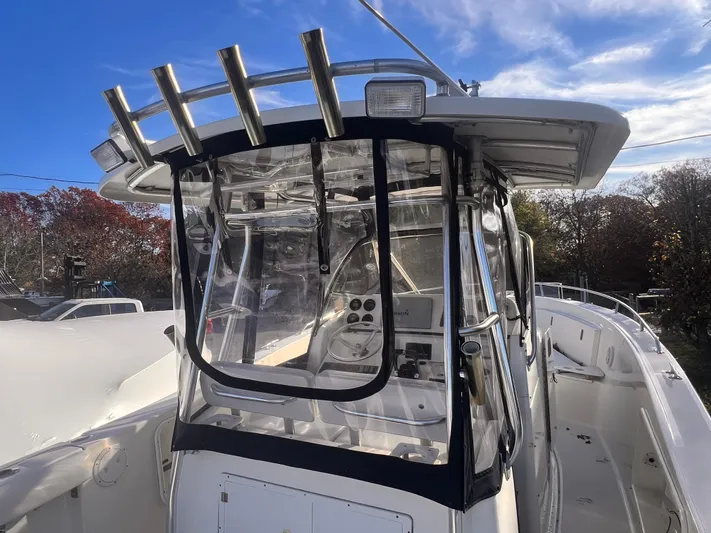  Yacht Photos Pics 2001 Pursuit 3070 Offshore Center Console boat with clear enclosure and rod holders.