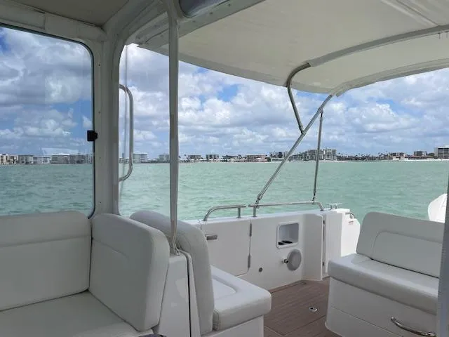  Yacht Photos Pics 2023 MJM 35z boat interior with white seating, overlooking calm waters and city skyline.