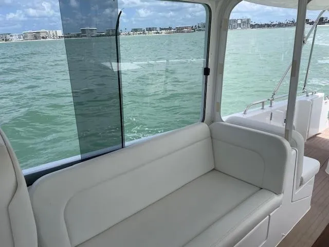  Yacht Photos Pics 2023 MJM 35z boat interior with white seating, overlooking calm waters and distant shoreline.
