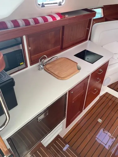  Yacht Photos Pics 2023 MJM 35z yacht interior with modern kitchen, wooden cabinets, and sleek countertop.