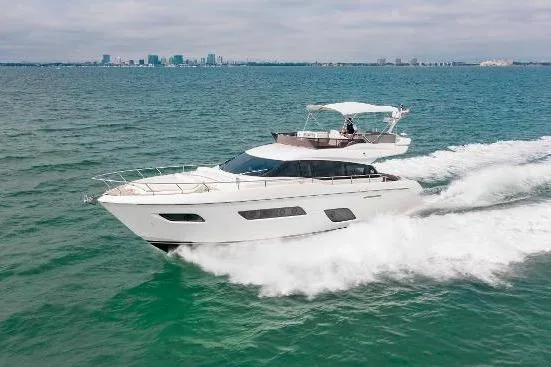  Yacht Photos Pics 2022 Ferretti Yachts 550 cruising on open water with city skyline in background.