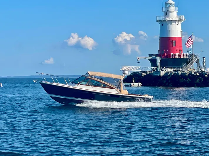  Yacht Photos Pics 2009 Hunt Yachts Harrier 29 cruising near a lighthouse on a sunny day.