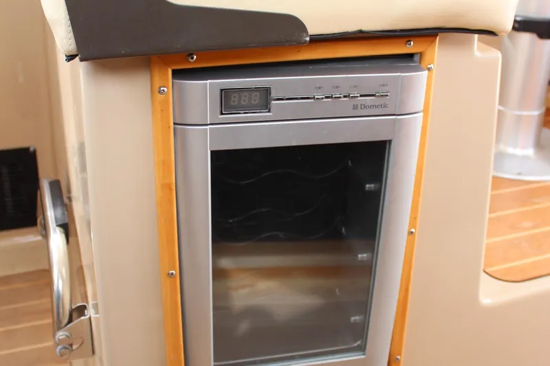 Shake N Bake Yacht Photos Pics Dometic fridge inside 2013 Cutwater 28 LE boat, featuring digital display and wooden trim.