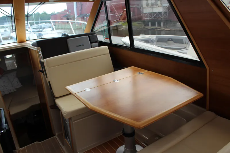 Shake N Bake Yacht Photos Pics Interior of 2013 Cutwater 28 LE boat with wooden table and beige seating.