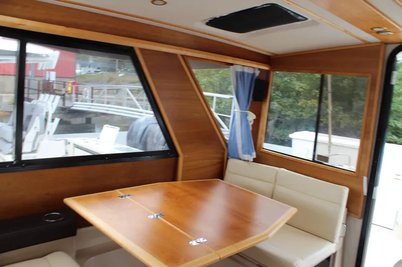 Shake N Bake Yacht Photos Pics Interior of 2013 Cutwater 28 LE boat with wooden table and cushioned seating.