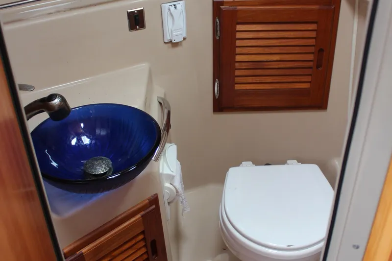 Shake N Bake Yacht Photos Pics 2013 Cutwater 28 LE bathroom with blue glass sink and wooden cabinet.