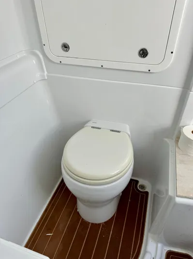  Yacht Photos Pics 2020 Yellowfin 42 Offshore boat bathroom with white toilet and wood flooring.