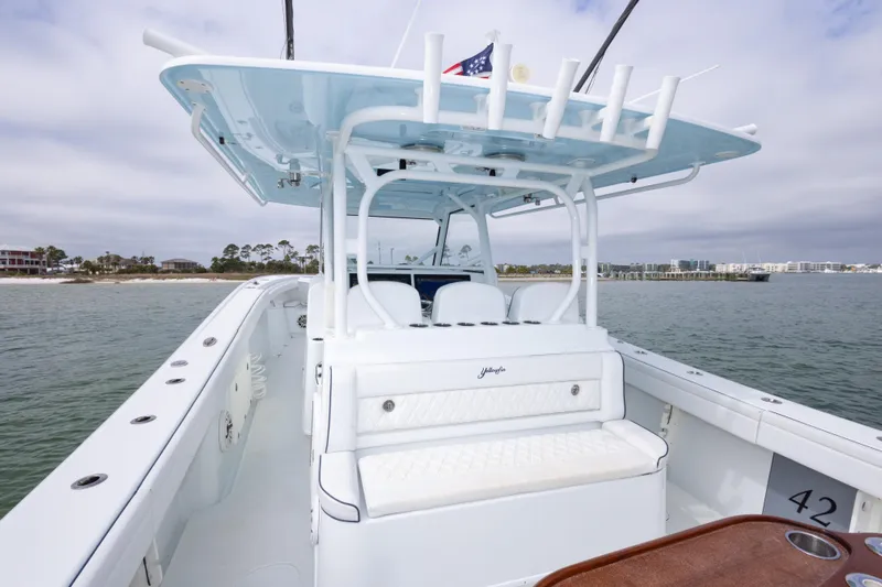  Yacht Photos Pics 2020 Yellowfin 42 Offshore boat with spacious deck and seating, cruising near the shoreline.