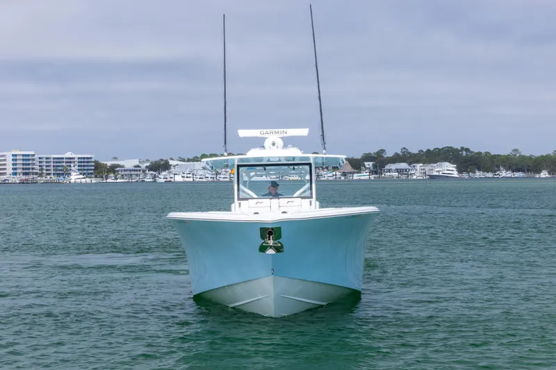  Yacht Photos Pics 2020 Yellowfin 42 Offshore boat on calm water with coastal buildings in background.