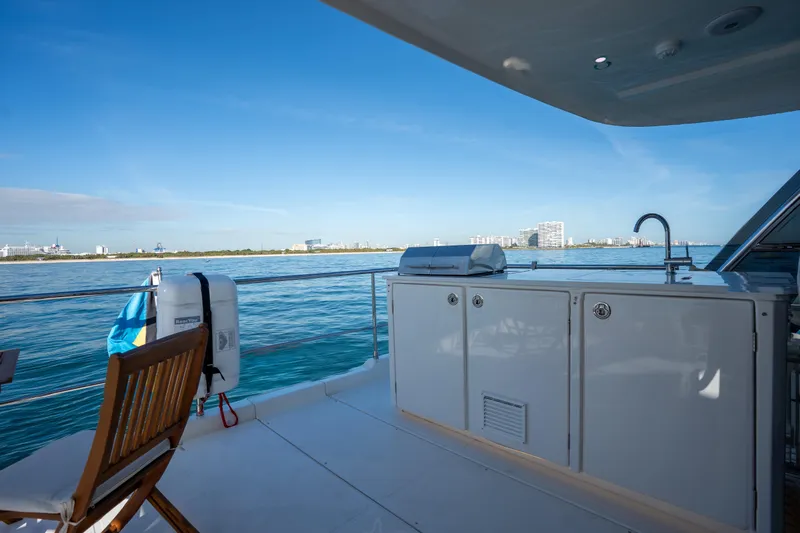  Yacht Photos Pics Aquila 54 Yacht 2025 deck with ocean view, featuring outdoor kitchen and seating.