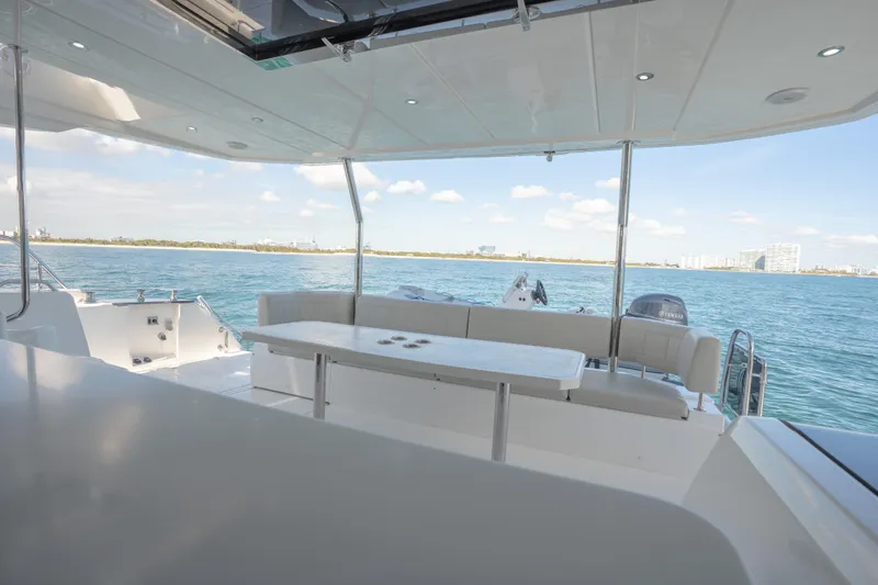  Yacht Photos Pics Luxurious 2025 Aquila 54 Yacht deck with seating, overlooking serene ocean view.