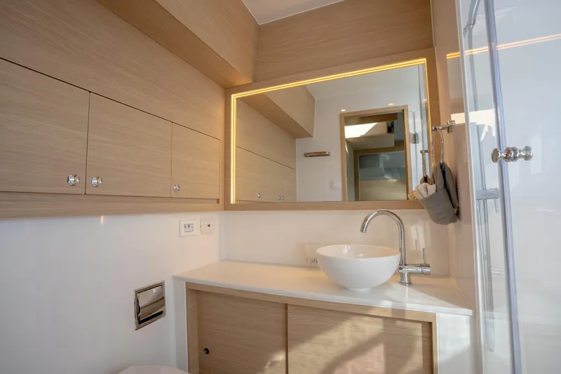  Yacht Photos Pics Luxurious bathroom interior of 2025 Aquila 54 Yacht with modern fixtures and wood accents.