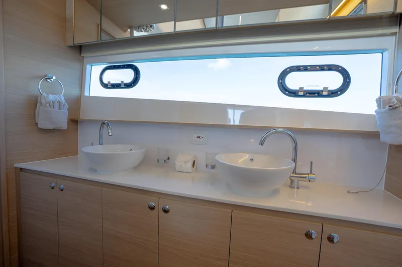  Yacht Photos Pics Luxurious bathroom interior of 2025 Aquila 54 Yacht with dual sinks and modern fixtures.