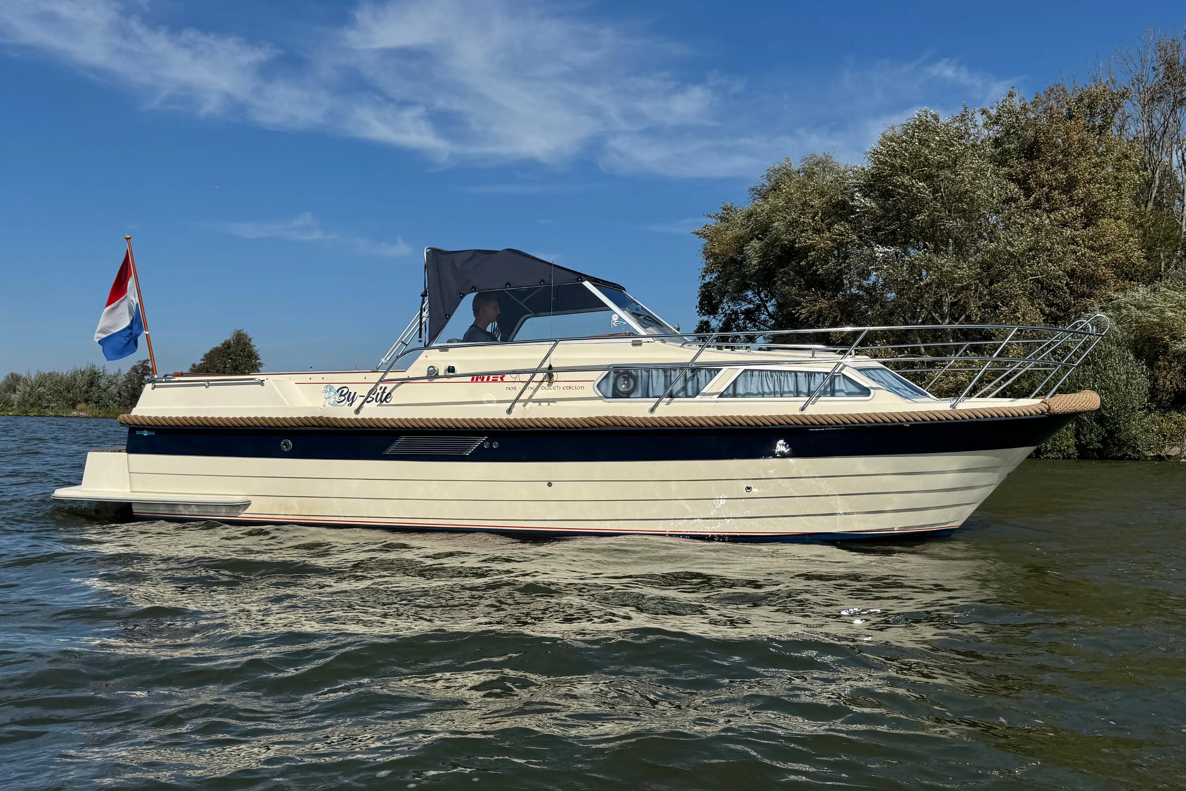 2008 INTER 9000 Sportivo boat cruising on a sunny day with a flag.