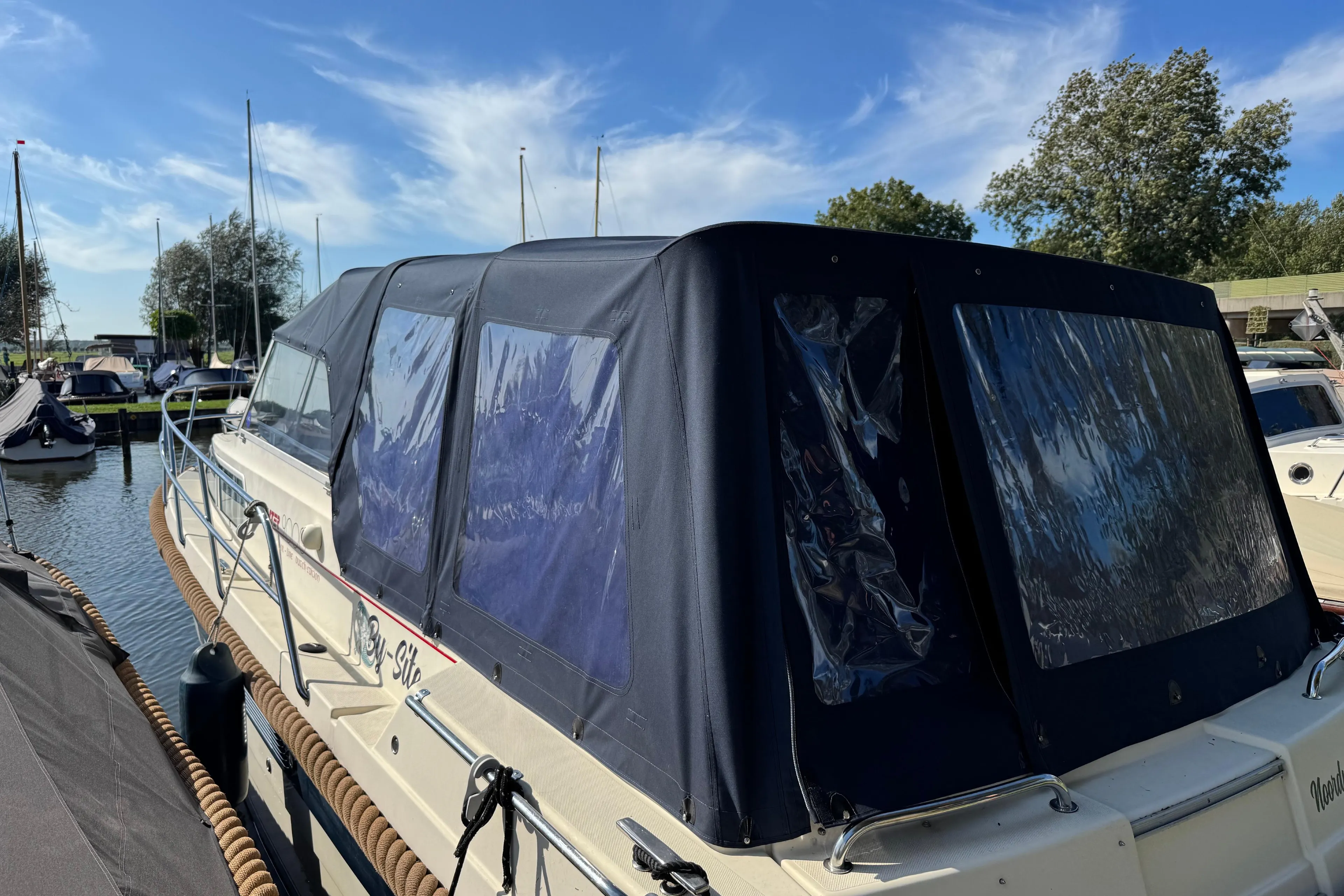 2008 INTER 9000 Sportivo boat docked with blue canopy under clear sky.