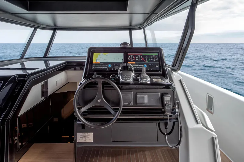  Yacht Photos Pics 2025 Bluegame BG54 yacht helm with advanced navigation system, steering wheel, and ocean view.
