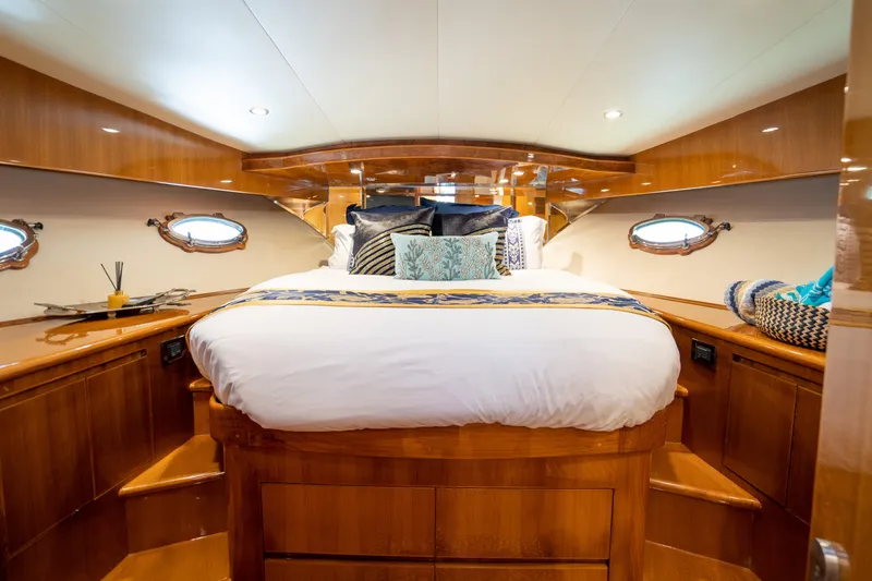  Yacht Photos Pics Luxurious 2007 Ocean Alexander 52 Pilothouse bedroom with elegant wood finish and cozy bedding.