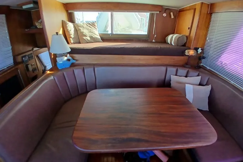 Concrete Idea Yacht Photos Pics Interior of 1977 Hatteras 48 Long Range Cruiser with cozy seating and wooden table.